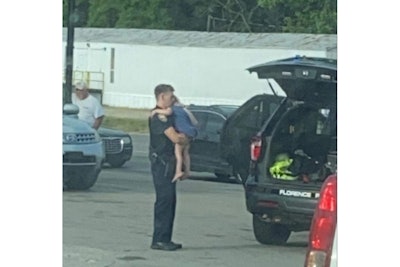 Officer Justin Whitten of the Florence (AL) Police Department comforts a child who has just witnessed her father attacking his family. (Photo: Florence PD/Facebook)