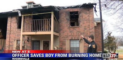 Rogersville, AL, police officer Tyler Dison points to the apartment where he rescued a 3-year-old from an arson fire Sunday. (Photo: WAAY screen shot)