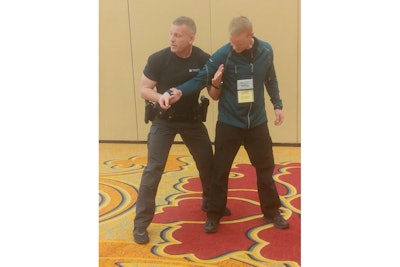 Dave Wright, chief master instructor for TASER training, demonstrates a technique with the assistance of Zach Zigterman, of the Plainfield (IL) Police Department.