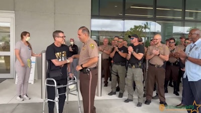 Miami-Dade Police officer Frank Sanguinetti is greeted by a large gathering of his law enforcement peers Tuesday as he leaves the hospital after multiple transplants during his COVID-19 recovery.