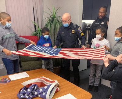 Richmond Heights Police Sgt. Todd Leisure teaches members of the Cop Scouts about the American flag, including how to fold one properly.