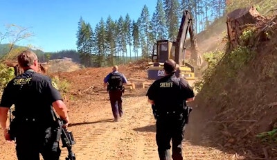 Two Washington County Sheriff’s Office, OR, deputies and a state trooper follow a wanted man on foot as he tries to evade arrest by fleeing on an excavator Sunday.