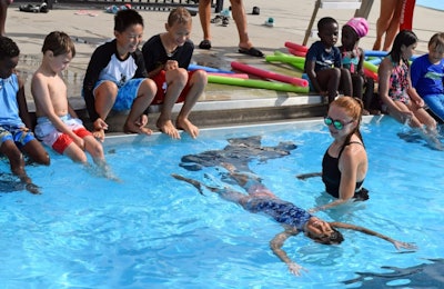 Officer Christine Larocque helps one of the students practice floating.