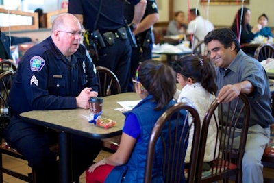 Sgt. Chris Cognac, during his days with the Hawthorne Police Department, is shown visiting with members of the public during Coffee with a Cop.