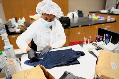 A GBI forensic biologist examines evidence for biological fluids.