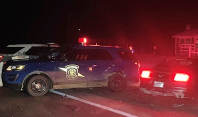 A suspected drunk driver hit a Michigan State Police vehicle, knocking it into two troopers, during a traffic stop Thanksgiving morning.