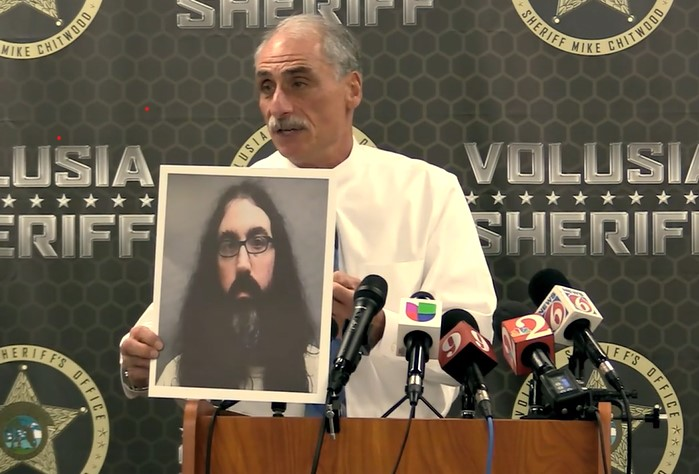 Volusia County, FL, Sheriff Mike Chitwood holds a photo of a New Jersey man who is being extradited to Florida over death threats against him.
