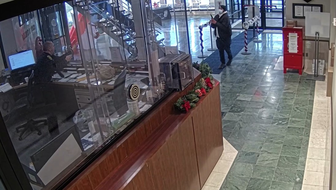 A front desk officer confronts an armed gunman who entered the lobby in December.
