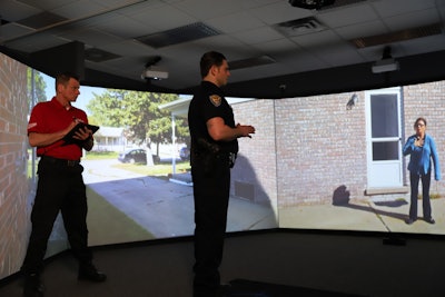 An instructor monitors a trainee's interaction during a simulation.