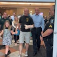 Wounded K-9 Handler Cpl. Matthew Aitken walks out of the hospital with his daughter and accompanied by Pinellas County Sheriff Bob Gualtieri.