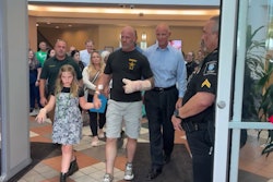 Wounded K-9 Handler Cpl. Matthew Aitken walks out of the hospital with his daughter and accompanied by Pinellas County Sheriff Bob Gualtieri.