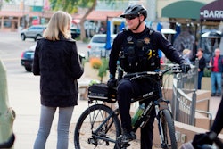 An officer speaks with a member of the community while on bike patrol. Community engagement is a large part of what bike officers do.
