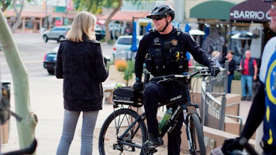 An officer speaks with a member of the community while on bike patrol. Community engagement is a large part of what bike officers do.