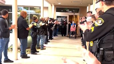 Officer Lina Mino is greeted by officers from several departments during her discharge from treatment in December.