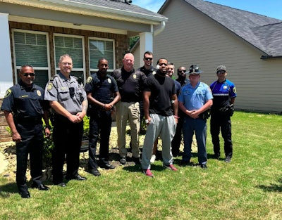 Officer Rashad Rivers (gray pants) outside his home with fellow officers after being released from hospital.