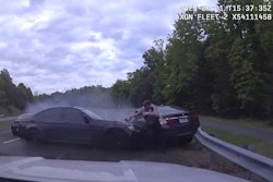 A Fairfax County, VA, police officer reacts as an out-of-control car crosses the highway and strikes the vehicle he has stopped. He was struck but only sustained minor injuries.