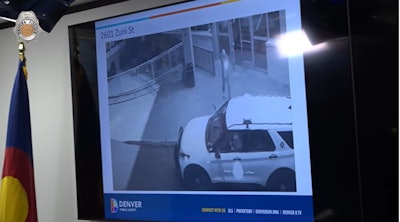 Surveillance camera video grab showing suspect firing on Denver officer outside of hotel. The officer was ambushed in his patrol vehicle.