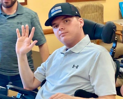 Officer Nicholas Wilt waves to well wishers as he leaves the rehabilitation center. Wilt was shot in the head by an active shooter in April.