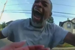 A still from a body camera video shows Winston Tate charging toward Detective Karli Travis wielding a hammer and yelling at the officer.