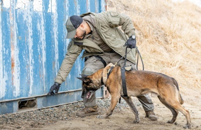 A handler trains a dog equipped with the Mission Ready Dog Leash, Aros K9 Harness, and Aros K9 Collar 1.0.