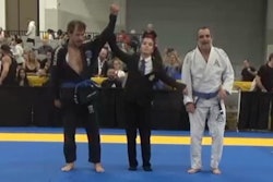 Referee raises Detective Bryan Ramsey's arm in victory during the International Brazilian Jiu-Jitsu Federation World Masters Competition in Las Vegas.