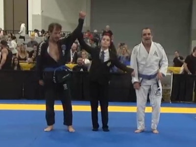 Referee raises Detective Bryan Ramsey's arm in victory during the International Brazilian Jiu-Jitsu Federation World Masters Competition in Las Vegas.
