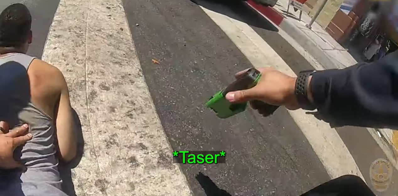 An LAPD officer tasers suspect Jose Delgado minutes after the man reportedly shot at officers driving on Pico Boulevard.