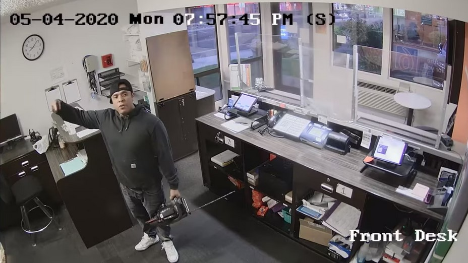 Photo showing Ronal Zendejas with a chainsaw inside the front office of a Sparks, Nevada, Motel 6.