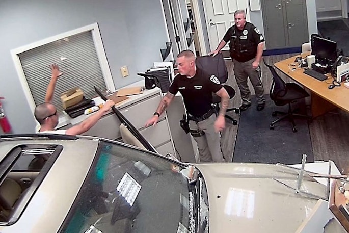 Independence Township, NJ, police officers take John G. Hargreaves into custody after the man drove an SUV into the police station on Sept. 20.
