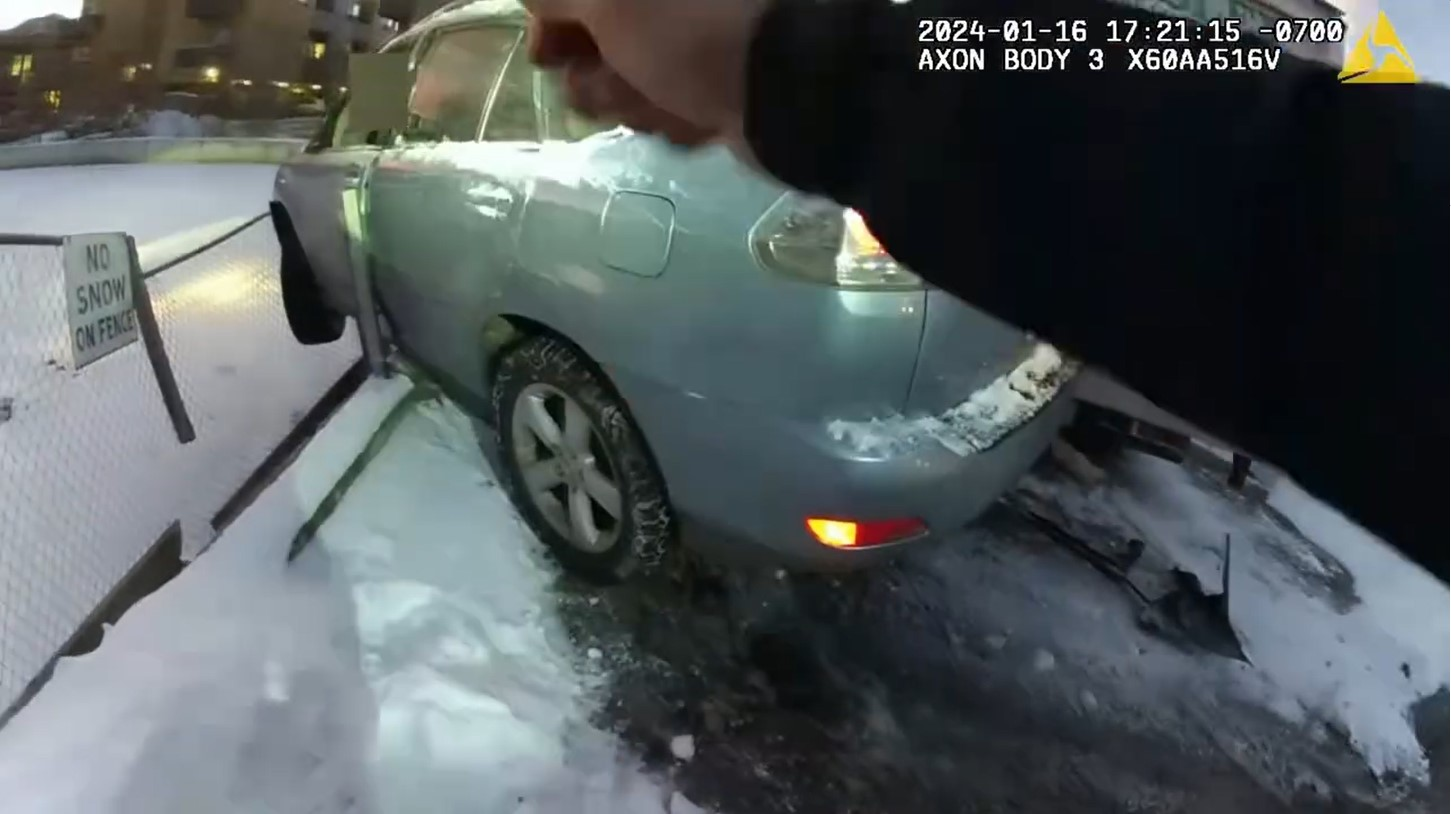 Boulder, Colorado, officers approach a crashed vehicle perched on a retaining wall. They were able to work with firefighters to rescue a toddler and the driver.
