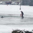 Commercial Motor Vehicle Officer Joe Schumaker walks out on a frozen pond in Dundee, Michigan. Schumaker fell through the ice taking a 12-year-old boy a flotation device.