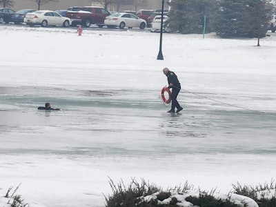 Commercial Motor Vehicle Officer Joe Schumaker walks out on a frozen pond in Dundee, Michigan. Schumaker fell through the ice taking a 12-year-old boy a flotation device.