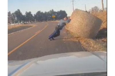 Missouri State Highway Patrol Trooper Isaiah Lemasters removes a haybale from a rural road.