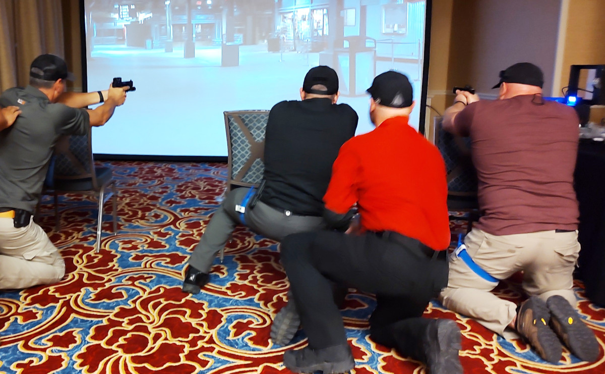 Trainers participate in a scenario that requires them first to apply a tourniquet, then stay in the fight and engage a threat during a VirTra simulation led by Lon Bartel.