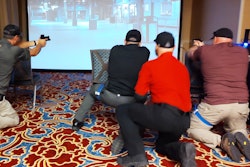 Trainers participate in a scenario that requires them first to apply a tourniquet, then stay in the fight and engage a threat during a VirTra simulation led by Lon Bartel.