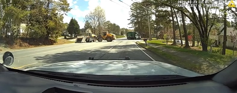 Officer's view of a front loader driven by a helpful civilian engaging with a front loader driven by a suspect during a Norcross, Georgia, incident Saturday. The good guy won, flipping the suspect's heavy equipment on its side. Police say no one was hurt.
