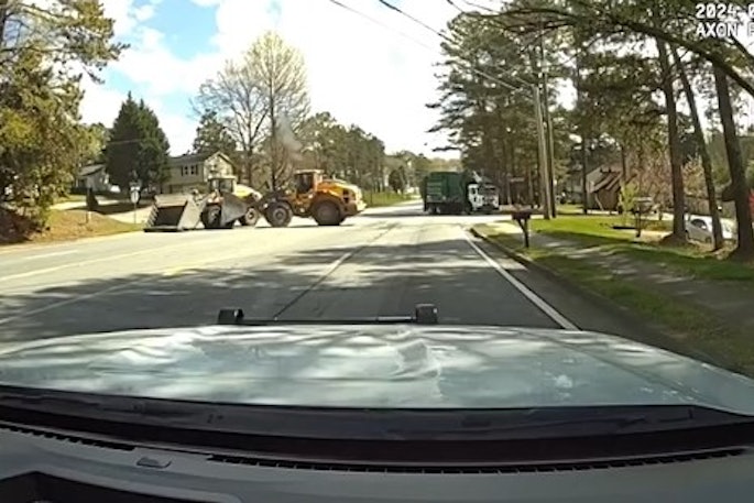 Officer's view of a front loader driven by a helpful civilian engaging with a front loader driven by a suspect during a Norcross, Georgia, incident Saturday. The good guy won, flipping the suspect's heavy equipment on its side. Police say no one was hurt.