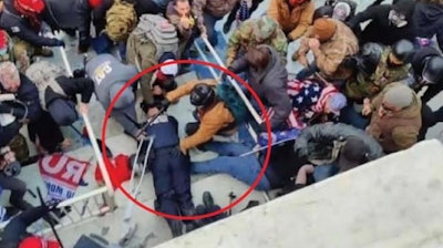 The Department of Justice says this photo shows Jeffrey Sabol holding a baton against the throat of a downed police officer during the Jan. 6, 2021, riot at the U.S. Capitol Building.