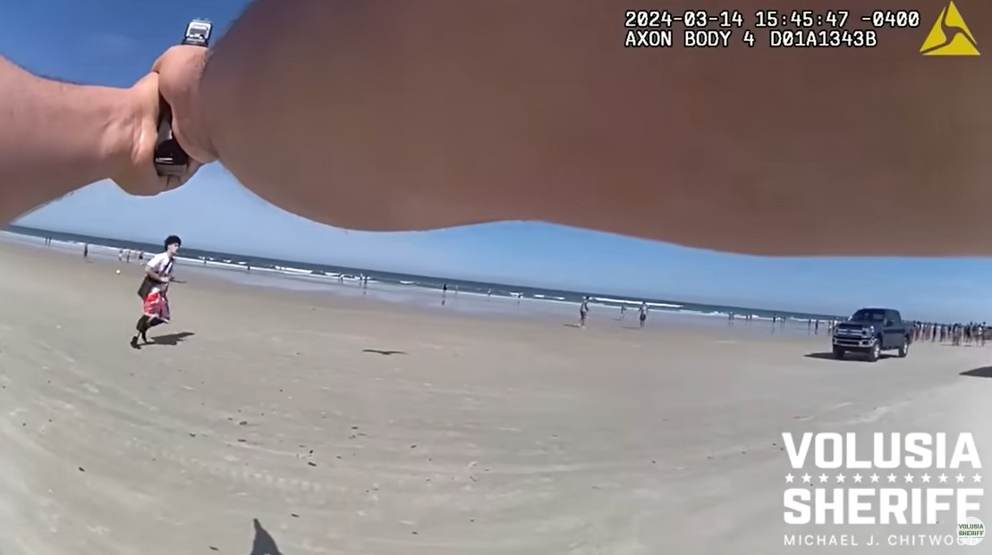 Volusia County, Florida, Sheriff's deputy pursues gun-wielding suspect toward the surf on New Smyrna Beach.
