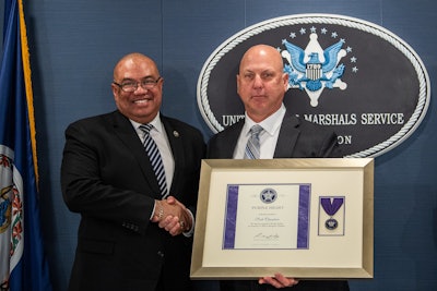 U.S. Marshals Service Director Ronald L. Davis (left) presents Chesapeake (Virginia) Sheriff’s investigator Scott Chambers with the agency's Purple Heart medal. Chambers was serving with a Marshals Service task force when he was shot multiple times by a murder suspect.