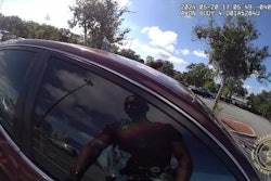 Flagler County Sheriff's Deputy Christian Harrison prepares to break a car window and rescue a trapped toddler from the heat of a Florida parking lot.