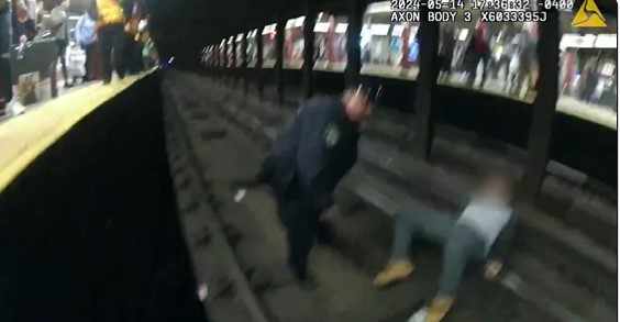 Screenshot from X video showing NYPD officer rescuing man from subway tracks.