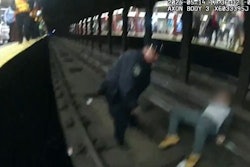 Screenshot from X video showing NYPD officer rescuing man from subway tracks.