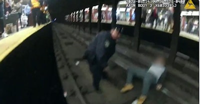 Screenshot from X video showing NYPD officer rescuing man from subway tracks.