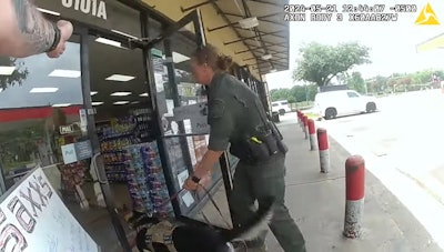 K-9 handler and dog enter a gas station on May 21 to confront the suspect. The officer withdrew with the dog after spotting the suspect's gun.