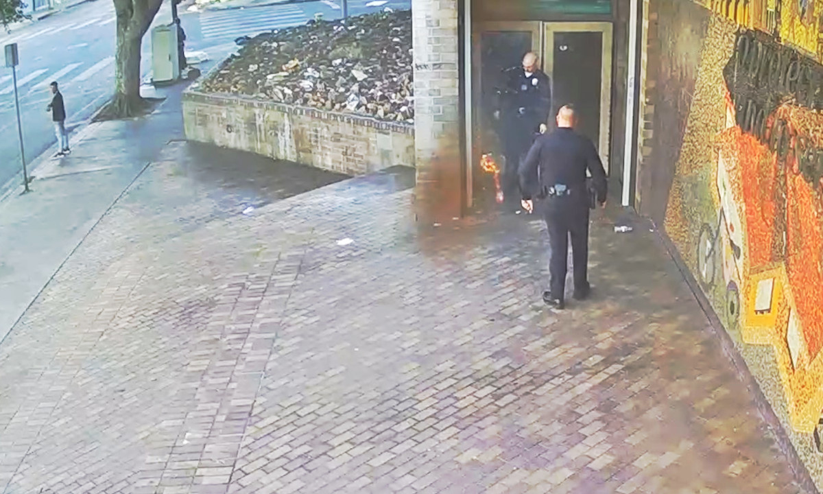 An officer is shown on video putting out the fire outside the LAPD station earlier this week.