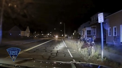 Massachusetts State Police say this suspect threw a hatchet at the passenger side windshield of a patrol vehicle. The blur on the right of this photo is reportedly the hatchet.