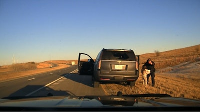 Kansas Highway Patrol trooper with 6-year-old kidnapping victim. The girl was discovered in an SUV with two 60-year-old men during a February traffic stop.