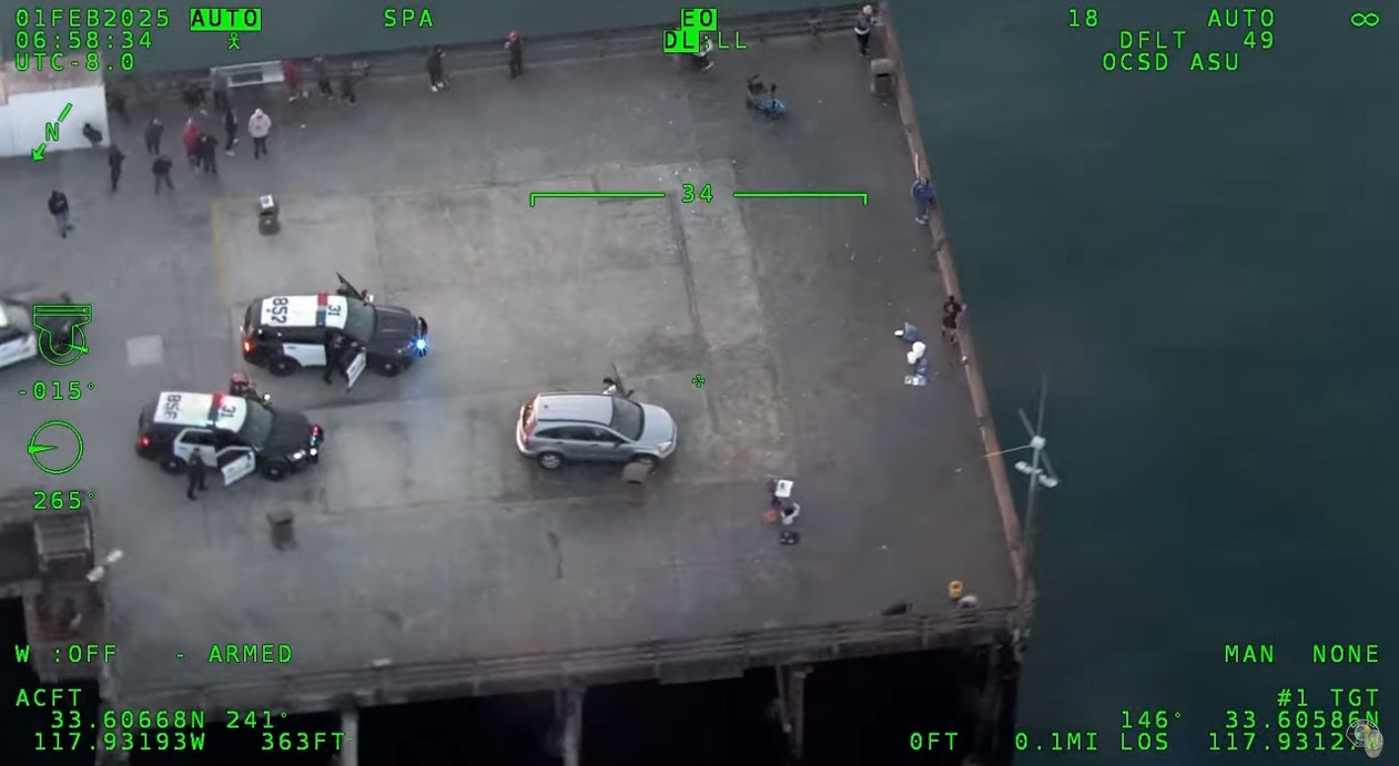 Still image from Orange County Sheriff's Department helicopter camera showing Santa Ana officers and suspect on Newport Beach Pier.