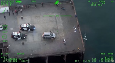 Still image from Orange County Sheriff's Department helicopter camera showing Santa Ana officers and suspect on Newport Beach Pier.